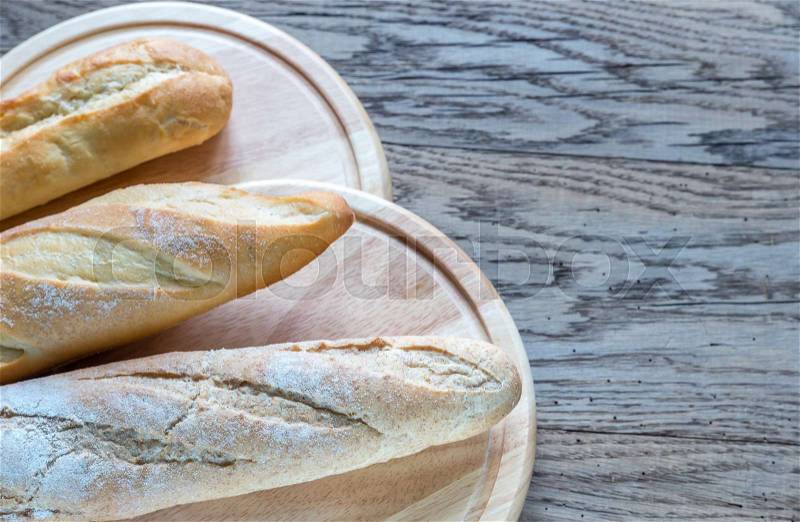 Three baguettes on the wooden background, stock photo