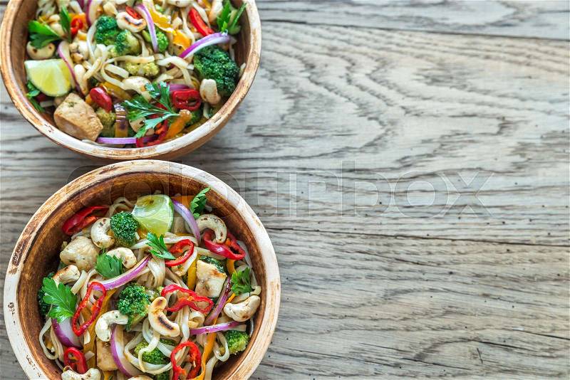 Two bowls of chicken noodle stir-fry, stock photo