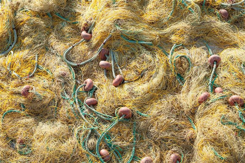 Yellow fishing net with green ropes drying on a pier, background photo, stock photo