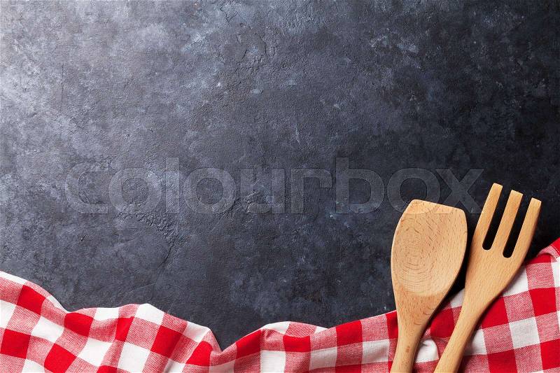 Towel and utensils over stone kitchen cooking table. Top view with copy space, stock photo