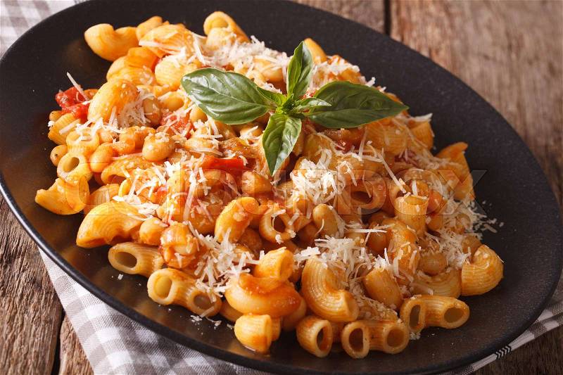 Pasta with tomatoes, beans and parmesan cheese on a plate close-up on the table. horizontal , stock photo