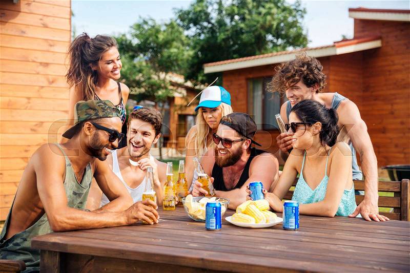 Portrait of cheerful young friends drinking beer outdoor summer party, stock photo