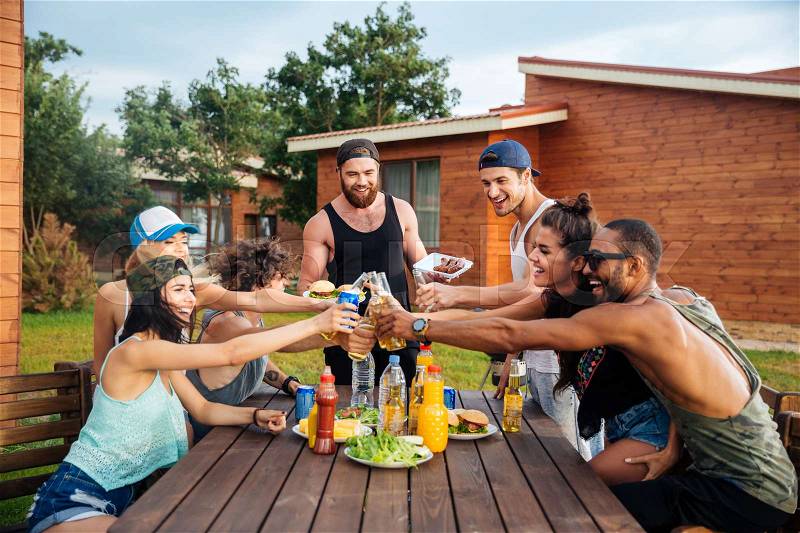 Group of happy young people celebrating and having outdoor party, stock photo