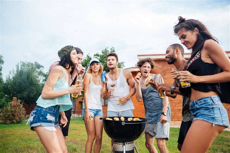 Group of young cheerful happy teens dancing at the picnic area, stock photo