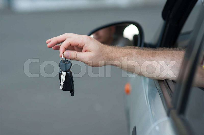 Men\'s hand holding a key from the car, symbolize joy purchase transport, crediting, driving. Buying a car, stock photo