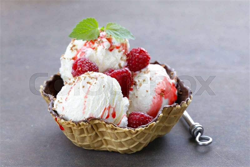 Homemade vanilla ice cream with berry sauce and raspberries, stock photo