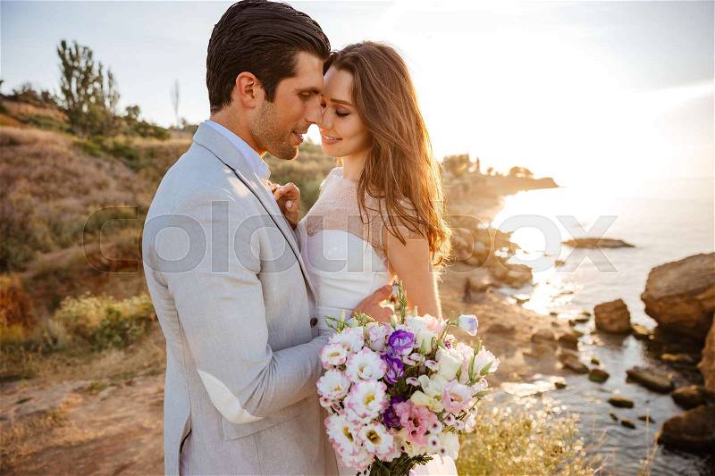 Happy just married young wedding couple celebrating and have fun at beautiful beach sunset, stock photo