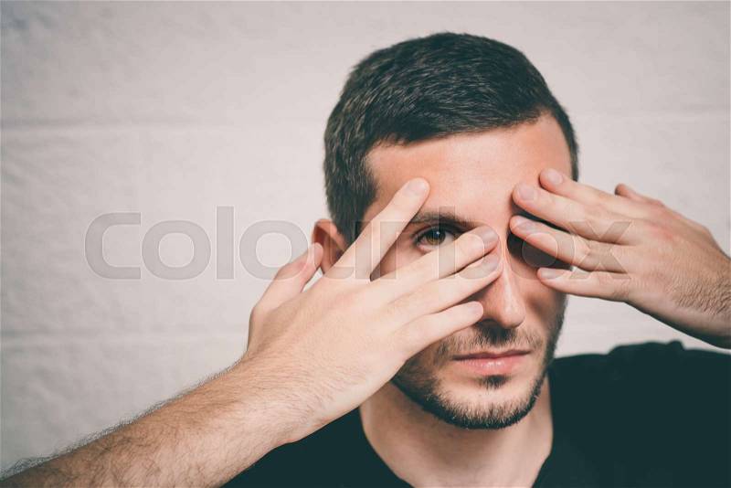 Man closes eyes with her hands, stock photo