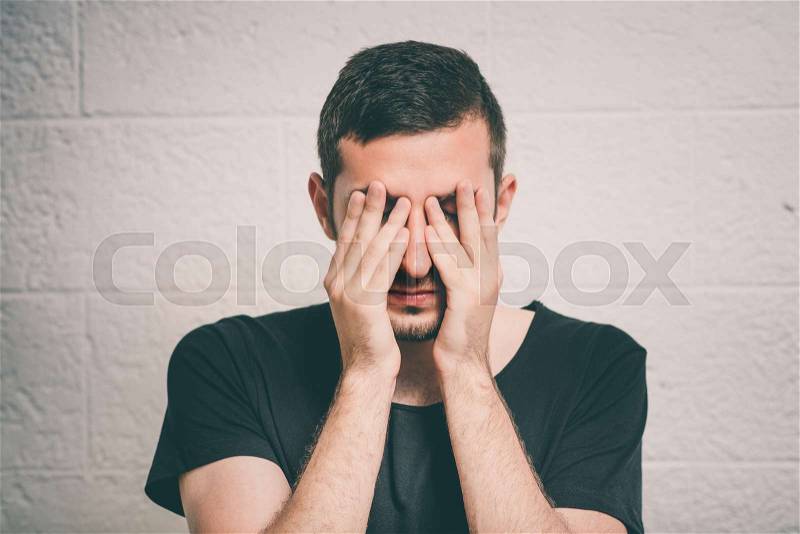 Man covering his face, stock photo