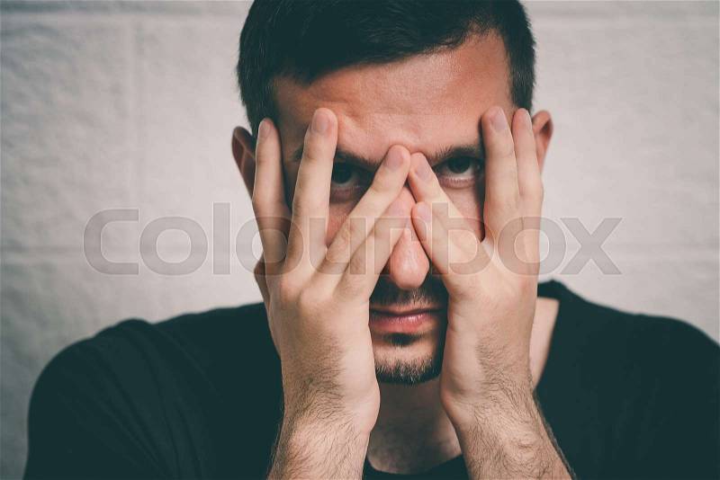 Man covering his face, stock photo
