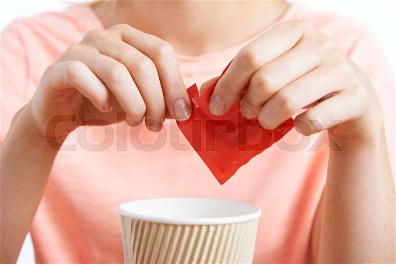 Woman Adding Artificial Sweetener To Coffee, stock photo
