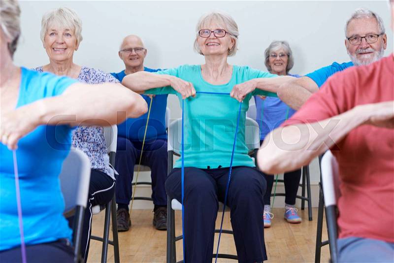 Group Of Seniors Using Resistance Bands In Fitness Class, stock photo
