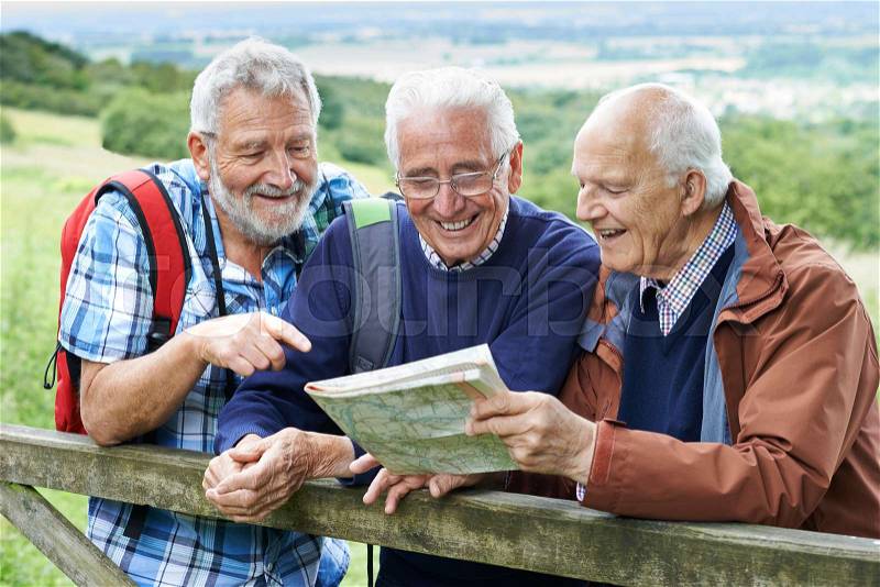 Group Of Senior Male Friends Hiking In Countryside, stock photo