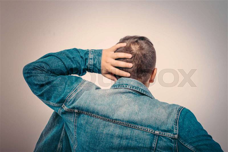Young man . Back view. On a gray background, stock photo