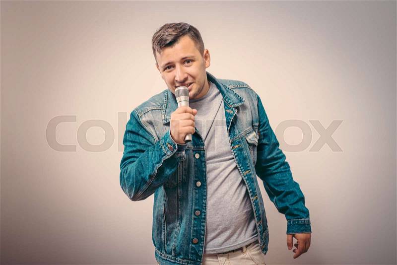 Handsome man singing to the microphone. Emotional portrait of an attractive guy, stock photo