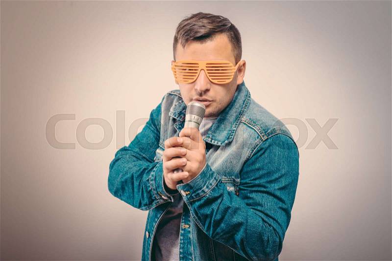 Handsome man singing to the microphone. Emotional portrait of an attractive guy, stock photo