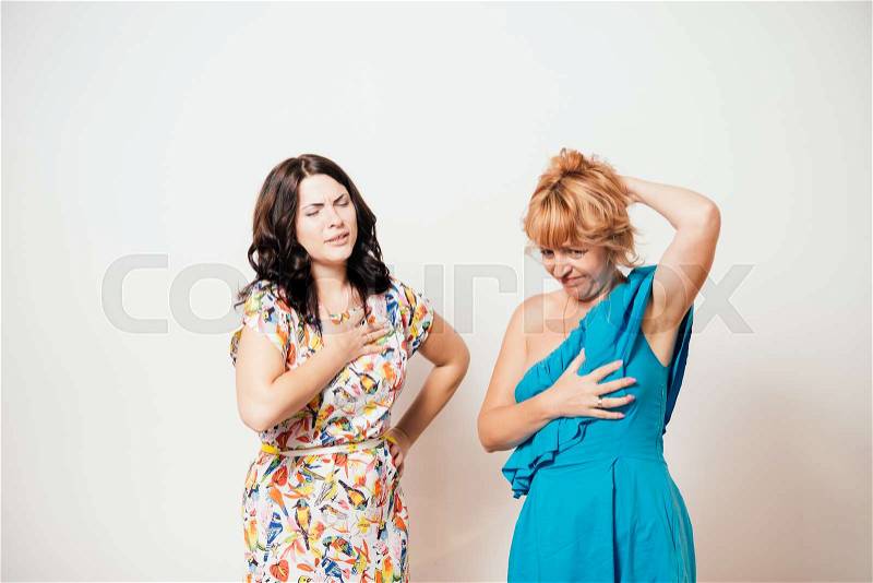 Two women feeling heart pain and holding her chest, stock photo