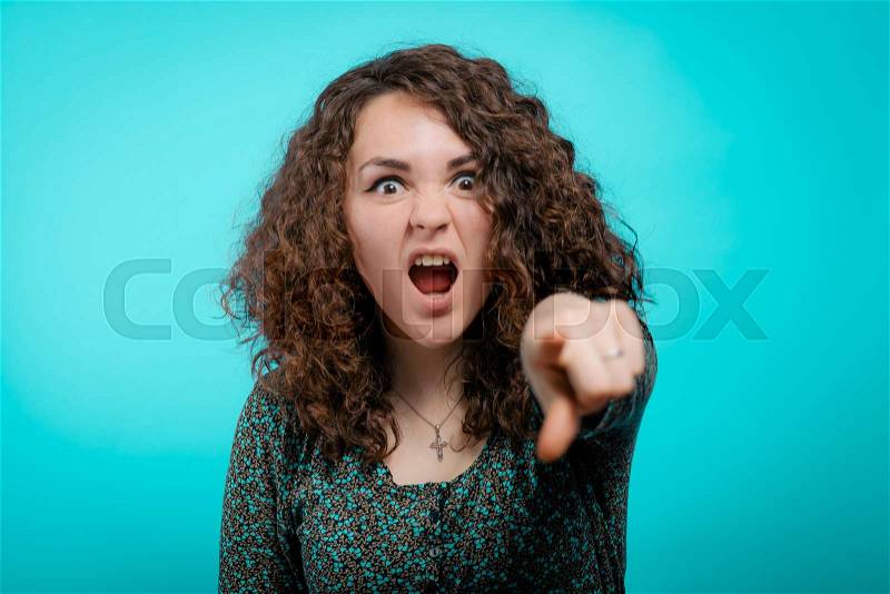 Angry woman scolding someone and pointing with her finger towards the camera, stock photo