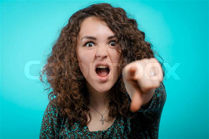Angry woman scolding someone and pointing with her finger towards the camera, stock photo