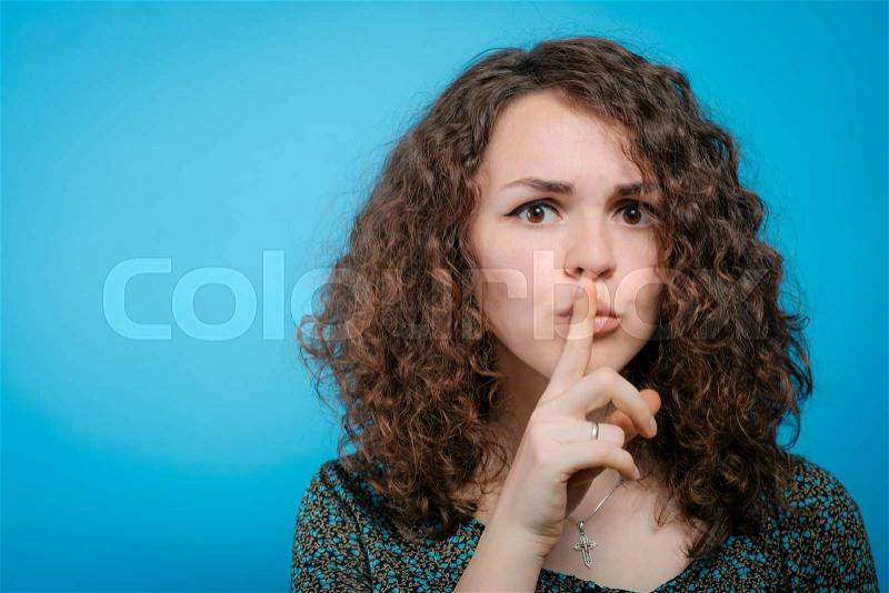 Woman put finger on her lips, stock photo