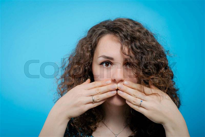 Girl laughs and covers her mouth, stock photo