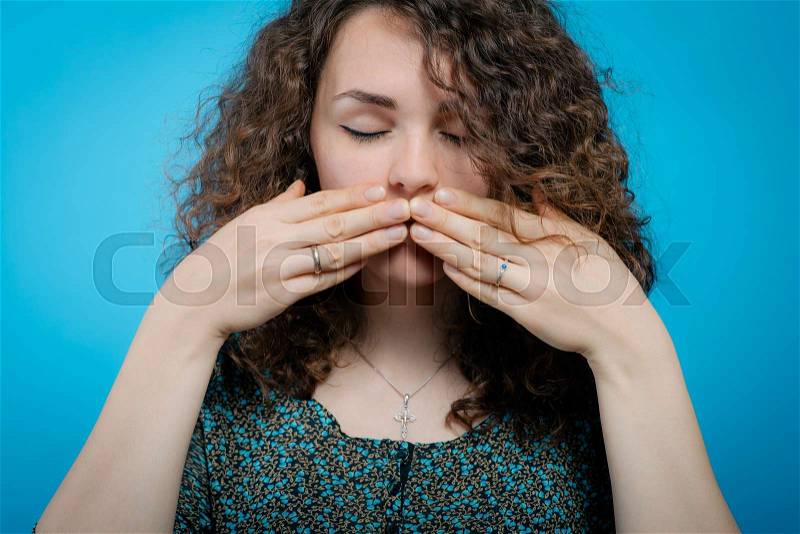 Girl laughs and covers her mouth, stock photo