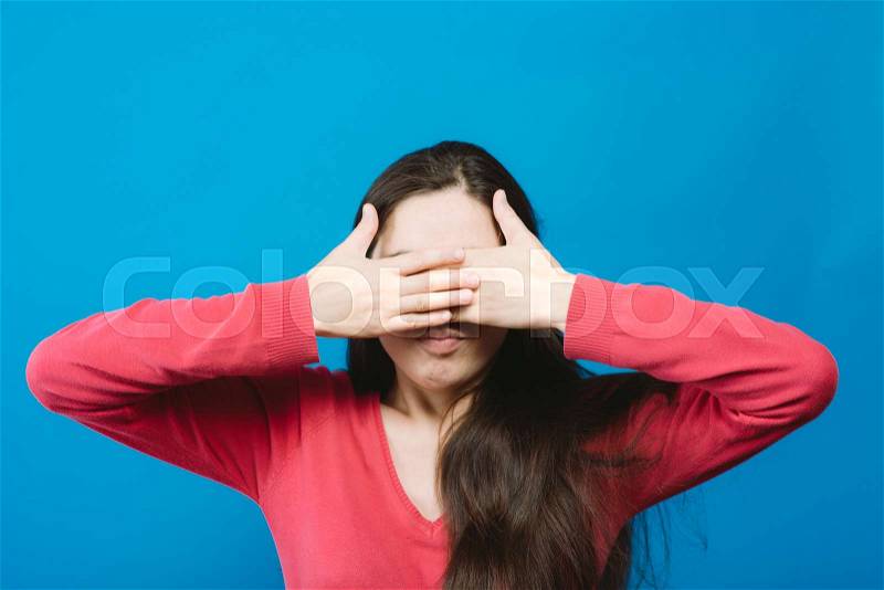 Woman closes eyes with her hands, stock photo