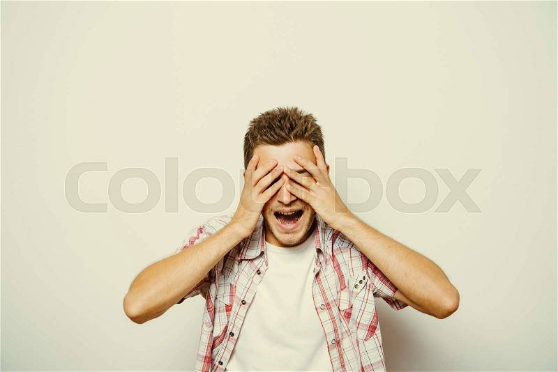 Man covered his face with his hands, stock photo