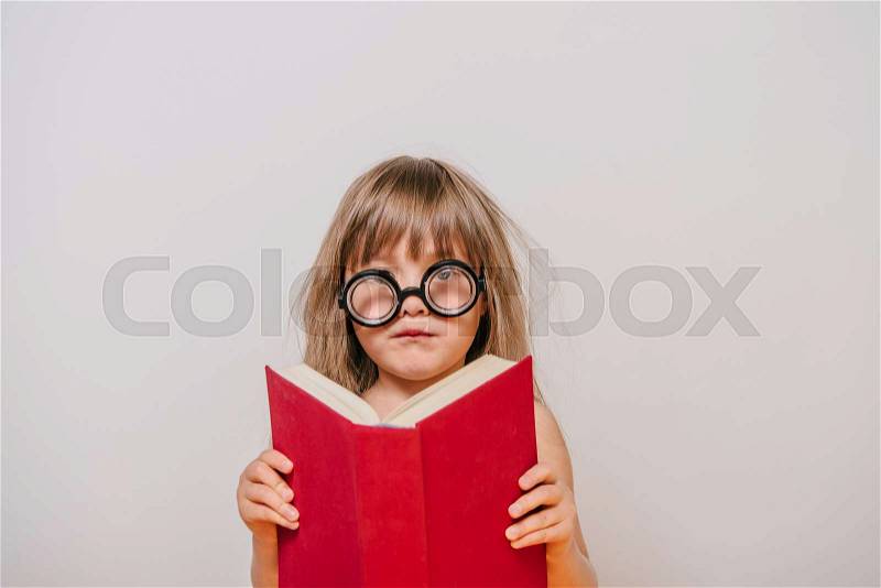 Girl with books. little girl in polka-dot dress. girl with thick book. a little girl with glasses and a book. girl reading. Girl learns. Little Girl tired to learn, stock photo