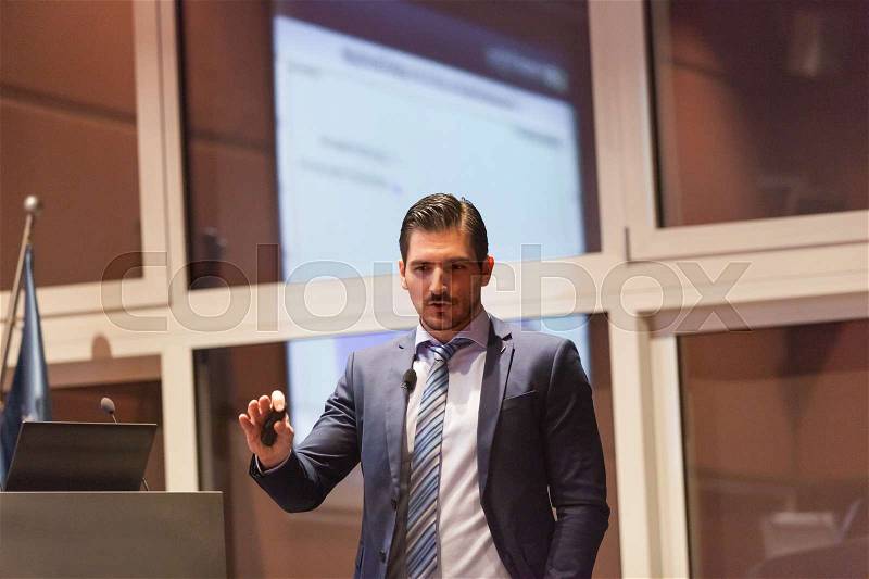 Speaker giving talk on podium at Business Conference. Entrepreneurship club. Horizontal composition, stock photo