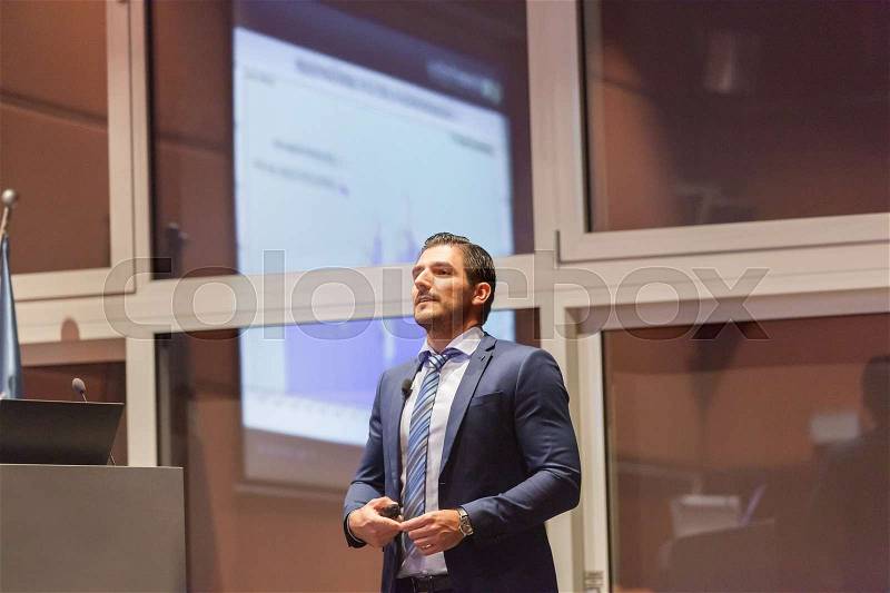 Speaker giving talk on podium at Business Conference. Entrepreneurship club. Horizontal composition, stock photo