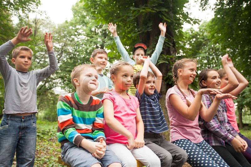 Group of positive children playing in the park sitting on the bench, stock photo