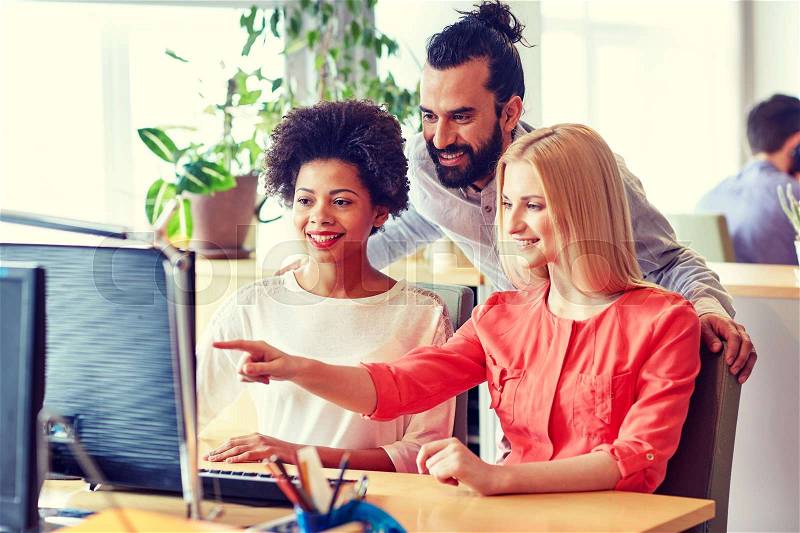 Business, startup and people concept - happy creative team networking with computer in office, stock photo