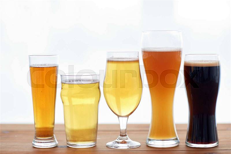 Brewery, drinks and alcohol concept - close up of different beers in glasses on table, stock photo