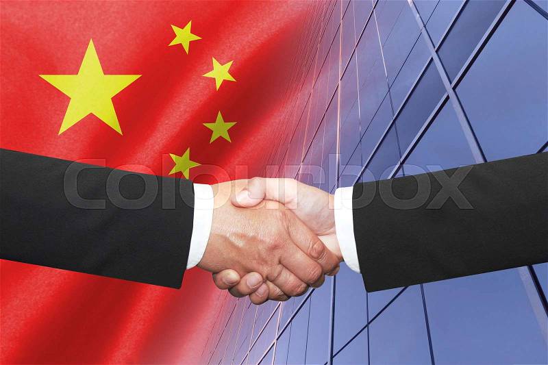 Two businessmen shakehand over china national flag, stock photo