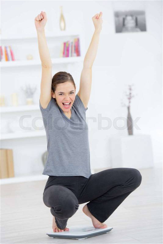 Woman on a weighing scale, stock photo