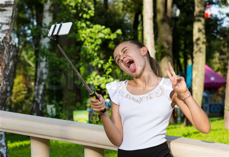 Girl doing selfie phone in a summer park, stock photo