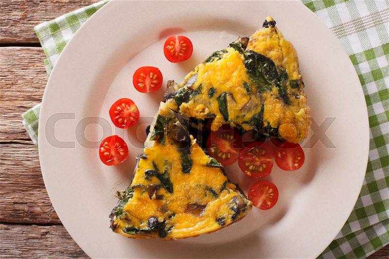 Frittata with spinach and mushrooms on a plate close-up. horizontal view from above , stock photo