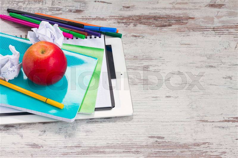 Back to school frame with school supplies and tablet with empty screen on wooden desktop, stock photo