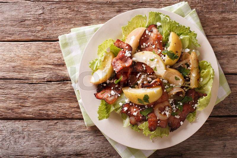 Swedish salad with fried bacon, green apple and goat cheese on a plate. Horizontal view from above , stock photo