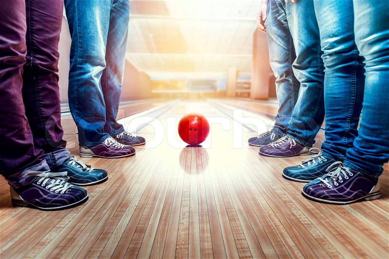 Many people standing near bowling ball on the lane, stock photo