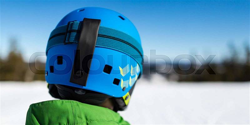 Close-up of young male skier standing on ski piste at ski resort on sunny winter day, stock photo