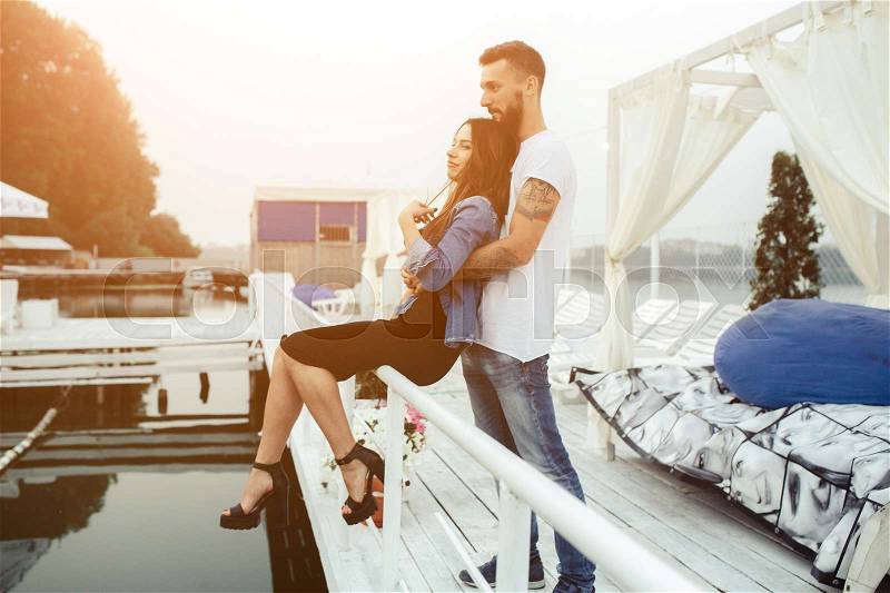Man hugging woman from behind on the pier, stock photo