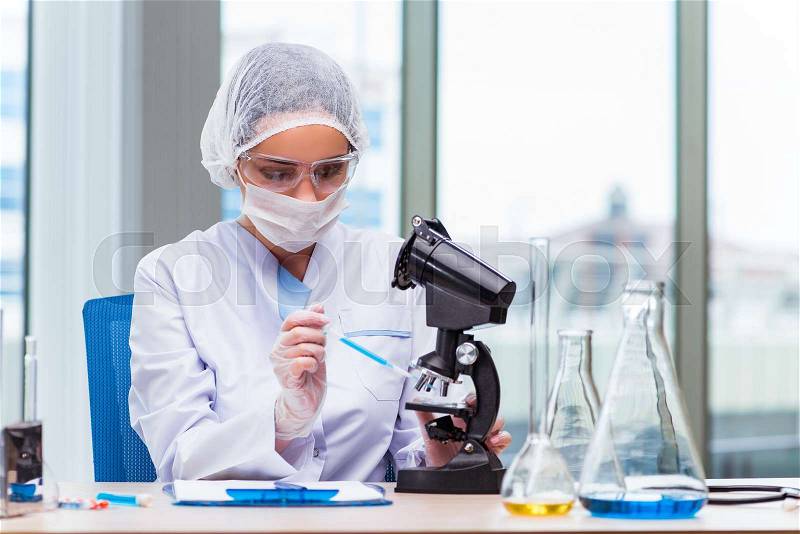 Young student working with chemical solutions in lab, stock photo