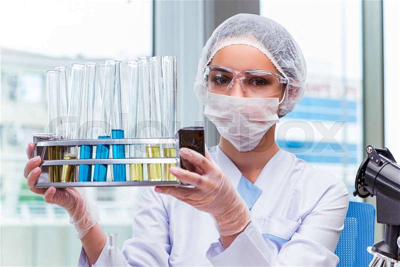 Young student working with chemical solutions in lab, stock photo