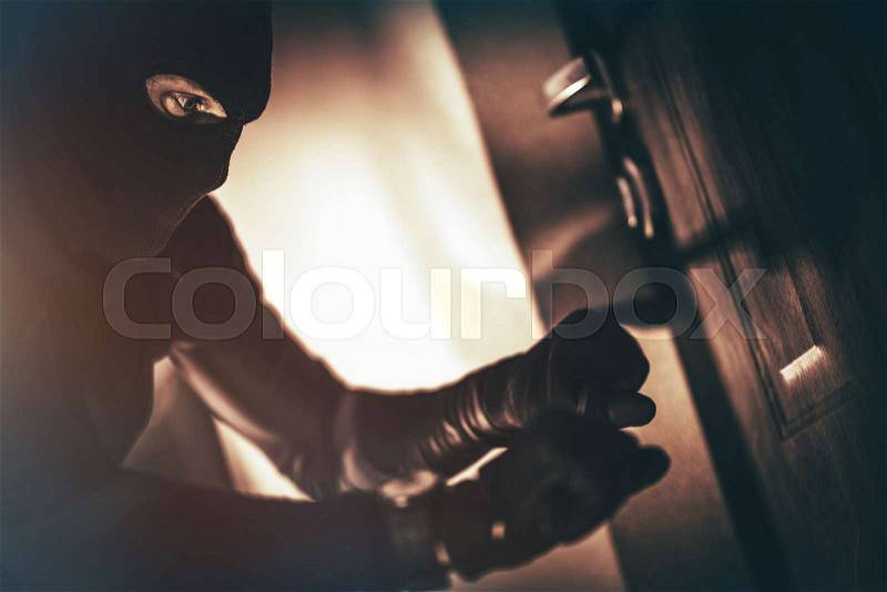 Caucasian House Burglar in Action. House Burglary Concept Photo. Home Safety Systems, stock photo