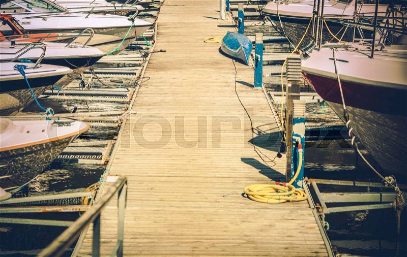 Small Motorboats Marina with Straignht Wooden Deck Alley. Boating and Fishing Theme, stock photo