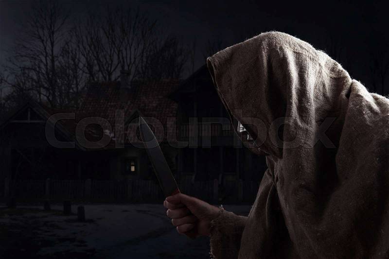 The hooded man with a big knife, stock photo