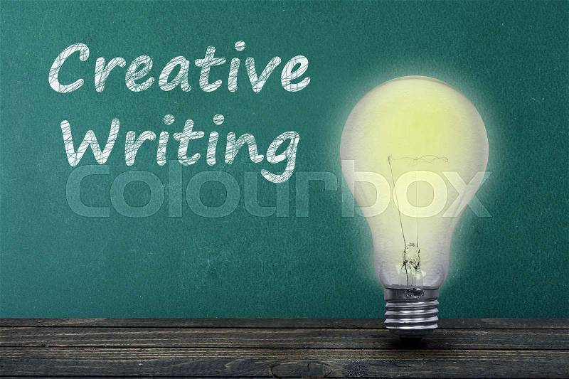 Creative Writing text on green board and light bulb on table, stock photo
