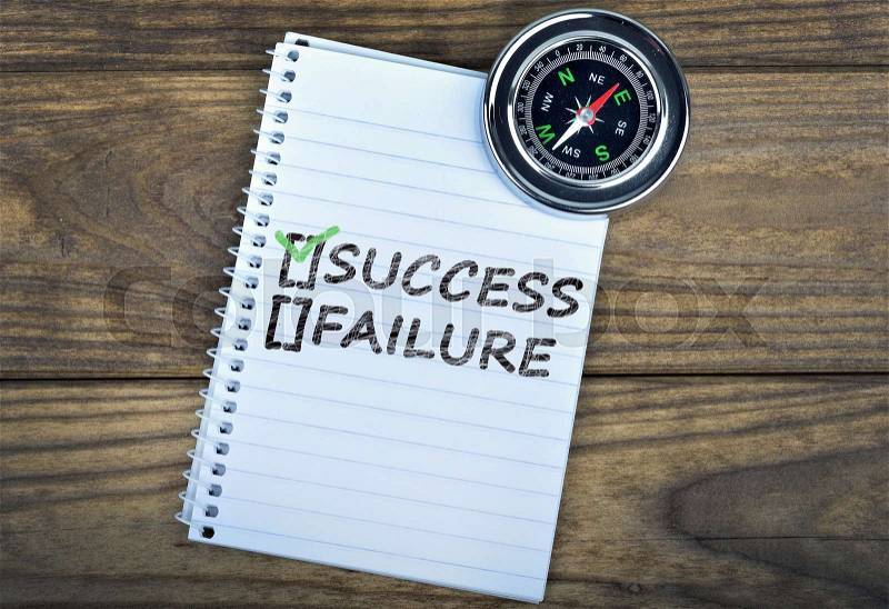 Success text and metallic compass on wooden table, stock photo